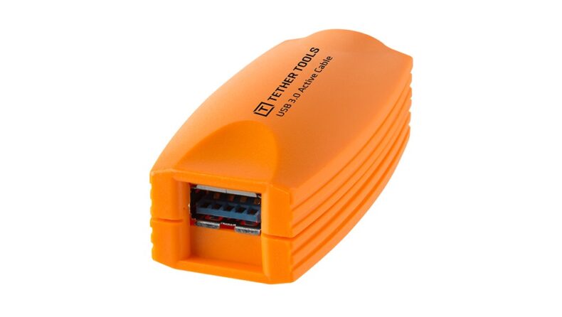 Dispositivo naranja de extensión USB 3.0 de la marca Tether Tools, diseñado para mejorar la conectividad en equipos profesionales de fotografía y vídeo, sobre fondo blanco.
